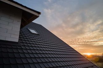 Closeup of house roof top covered with ceramic shingles. Tiled covering of building