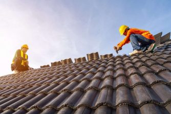 Two Roofer working on roof structure of building on construction